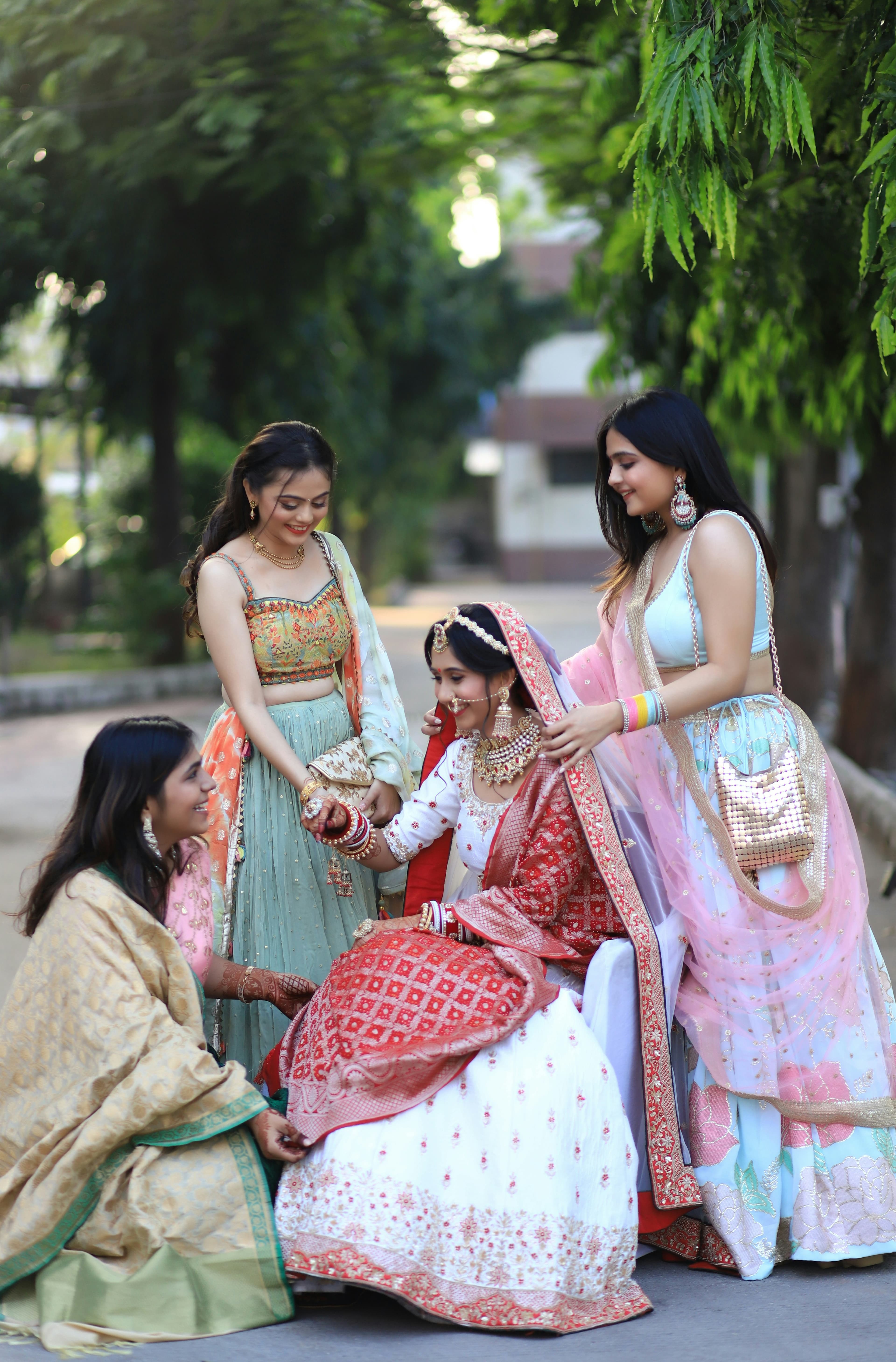 bride is sitting on a chair sorrounded by her besties